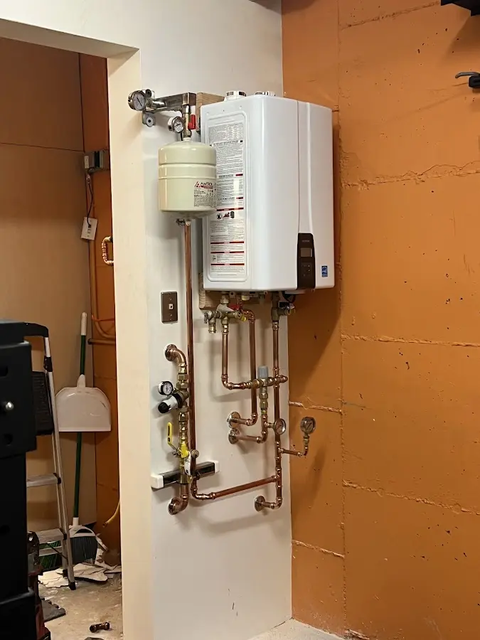 Plumbing technician inspecting water heater connections in Middlebury